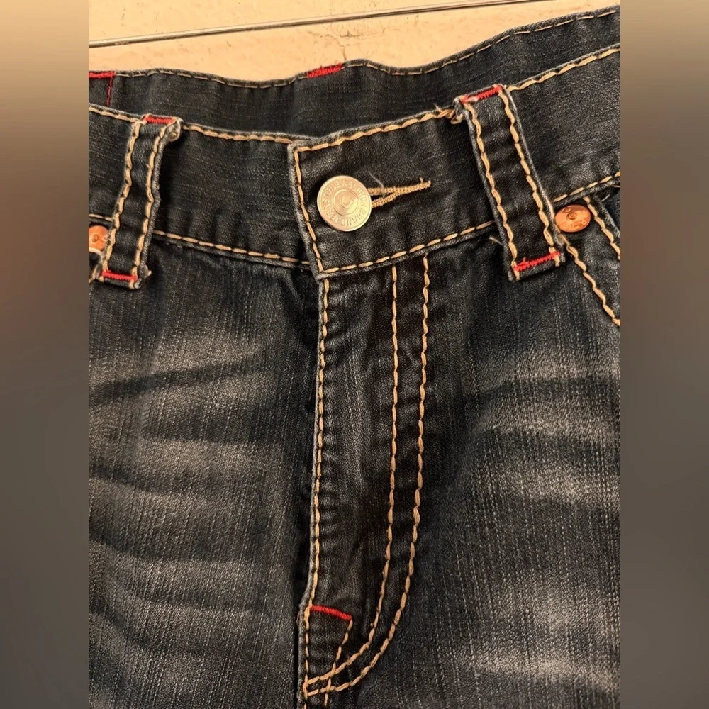 True Religion jeans feature a dark wash and bold signature stitching. Skinny